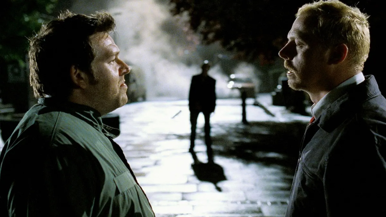 Shaun and Ed Staring at Each other with a Zombie in the background