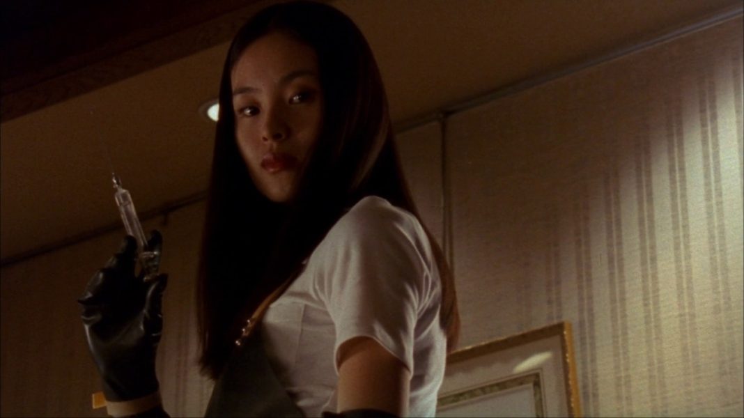 Eihi Shiina as Asami Yamazaki holding a syringe in Audition (1999).