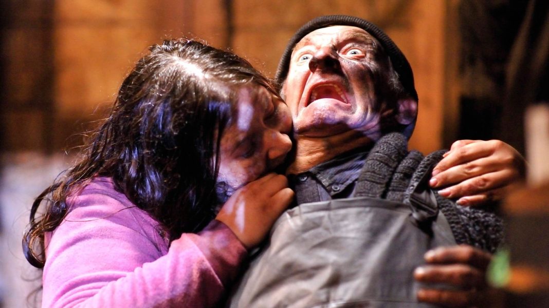 A zombie woman biting a man in Survival of the Dead (2009).