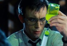 Herbert West (Jeffrey Combs) gets a dose of the glowing reanimating reagent in a syringe in Re-Animator