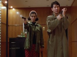 Two actors holding guns from On the Run (1988)