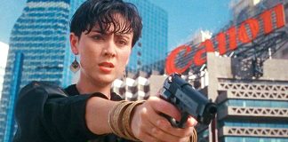 A woman points a gun at someone in She Shoots Straight (1990)