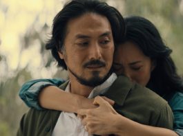 Keiko Miura (Mari Yamamoto) hugs Hiroshi Randa (Takehiro Hira) from behind while crying in Legacy of Monsters Season 2, Episode 5 'Furusato'
