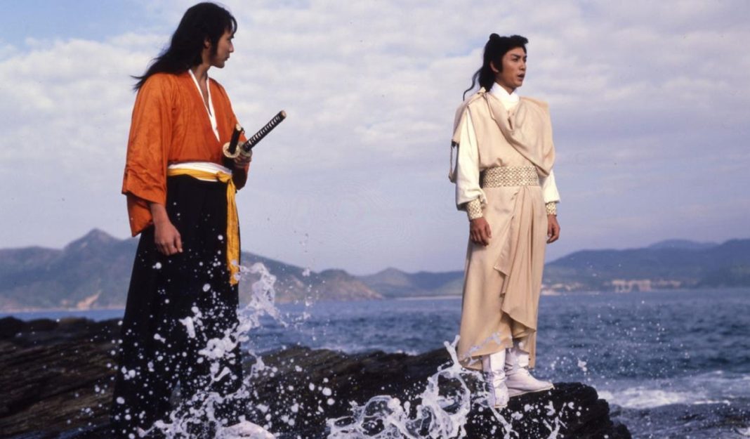 Two men stand on a rock on the seashore in DUEL TO THE DEATH