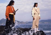 Two men stand on a rock on the seashore in DUEL TO THE DEATH