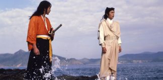 Two men stand on a rock on the seashore in DUEL TO THE DEATH