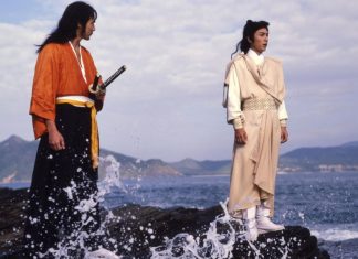 Two men stand on a rock on the seashore in DUEL TO THE DEATH
