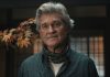 An older Lee Shaw (Kurt Russell) looks concerned while standing in house in Monarch Legacy of Monsters Season 2, Episode 7