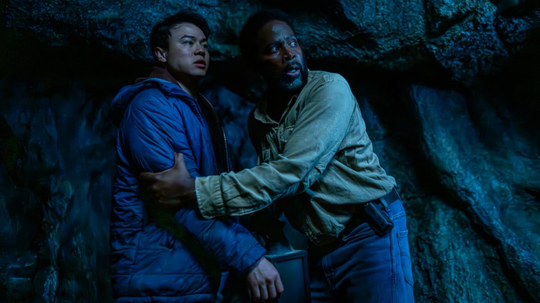 Boyd grabs Kenny Liu's arms while they stand in a cave in FROM Season 4 Episode 1