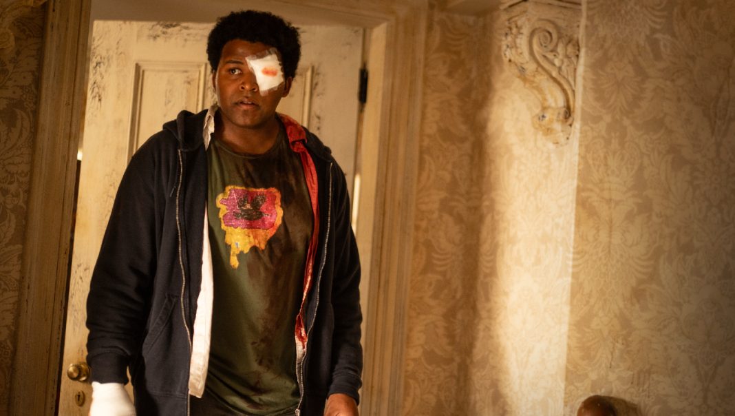 Elgin, battered with a bandage on his eye, walks into the house in From Season 4 Episode 2