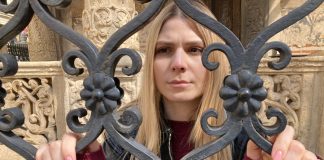 A woman stands at a gate in Transylvania Tapes