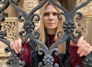 A woman stands at a gate in Transylvania Tapes