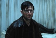 Adam Scott's character looks stunned while covering in a substance in Hokum