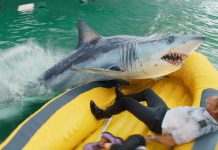 In a life raft, Aaron Eckhart's character fights off a shark in Deep Water