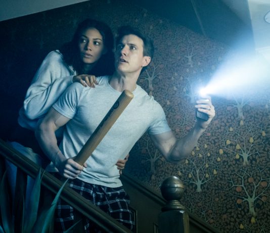 A husband and wife come down the stairs in fear in the Paranormal Activity Stage Play