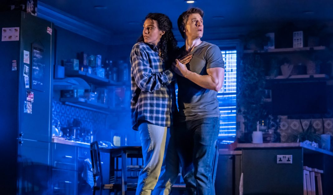 A husband and wife hold each other in fear in the Paranormal Activity Stage Play
