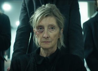 A woman gets pushed in a wheelchair to a funeral in The Voices of Our Mother