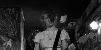 ‘The Yellow Bellies’ Blu-ray Review: A Gritty, Raw Punk Story A woman plays the guitar while on stage in The Yellow Bellies