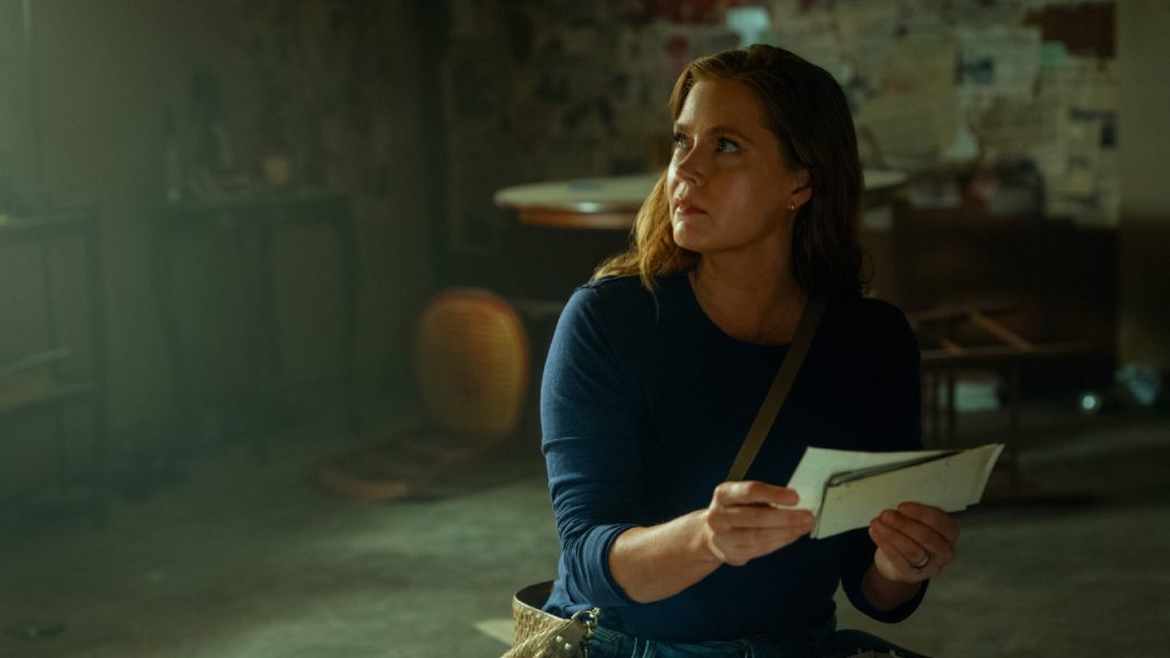Anna (Amy Adams) looks through photos in Cape Fear Episode 9
