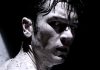 A man, covered in dark liquid, turns around in Tetsuo The Bullet Man