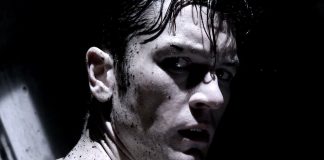 A man, covered in dark liquid, turns around in Tetsuo The Bullet Man