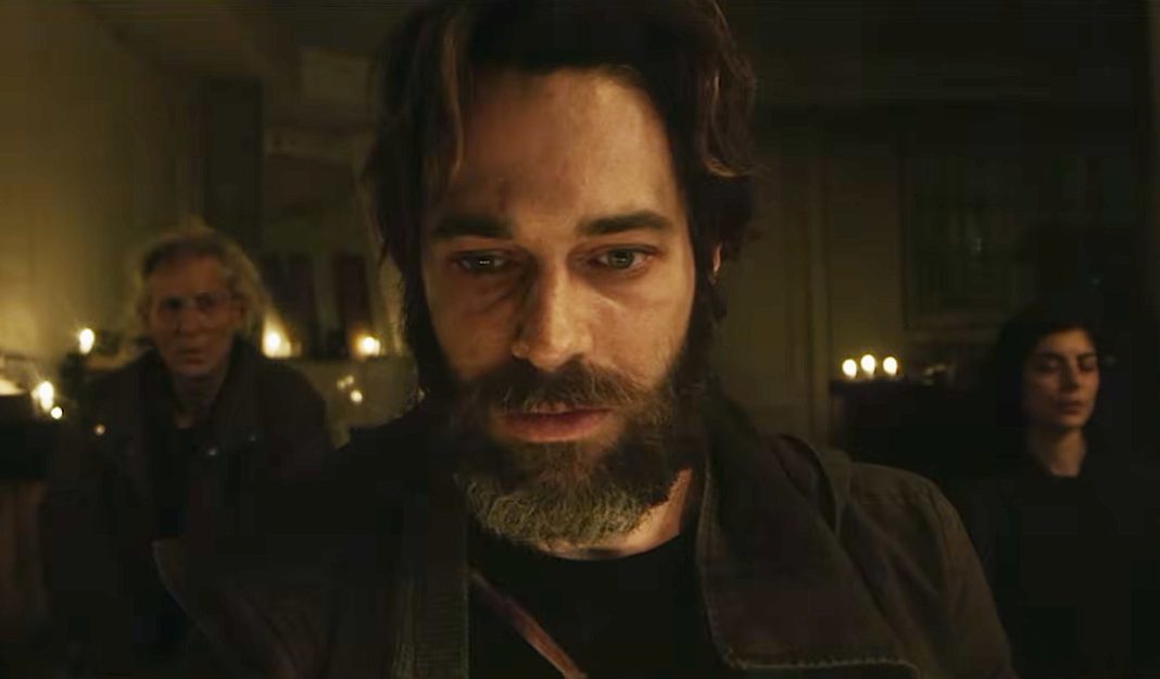 A man looks at a book in shock in PORTRAITS OF THE APOCALYPSE A man looks at a book in shock in PORTRAITS OF THE APOCALYPSE