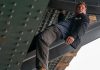 Reacher holds onto a beam under a bridge in Reacher Season 4