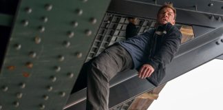 Reacher holds onto a beam under a bridge in Reacher Season 4