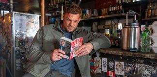 Reacher reads a Lee Child book in a diner in Reacher Season 4
