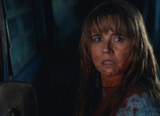 Pam Voorhees (Linda Cardellini) stands next to a truck, covered in blood, in Crystal Lake