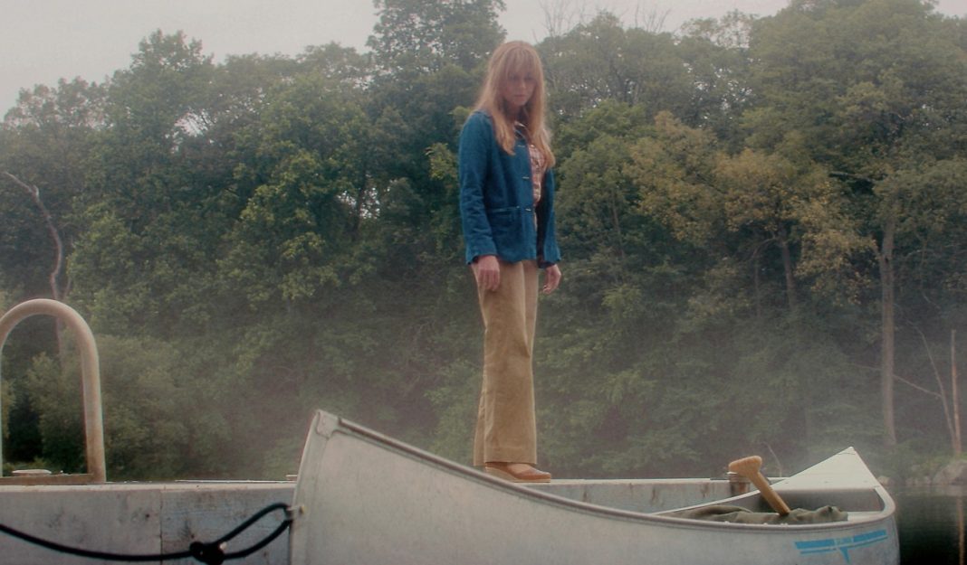 Pam Voorhees (Linda Cardellini) stands on a dock next to a canoe in Crystal Lake