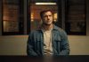 Reacher sits at a police desk in Reacher Season 4